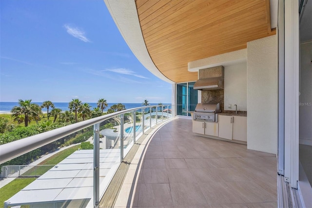 balcony featuring grilling area, area for grilling, sink, and a water view