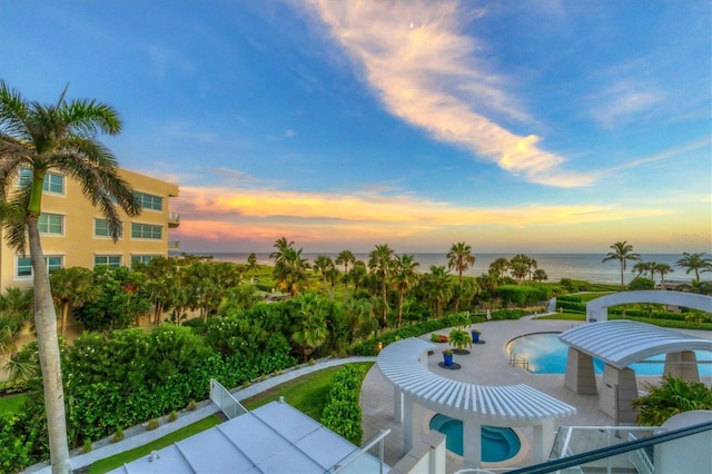 exterior space with a patio area, a water view, and a hot tub