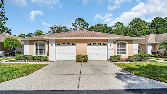 single story home with a garage and a front lawn