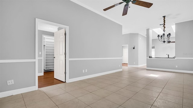 tiled spare room featuring crown molding, high vaulted ceiling, and ceiling fan with notable chandelier