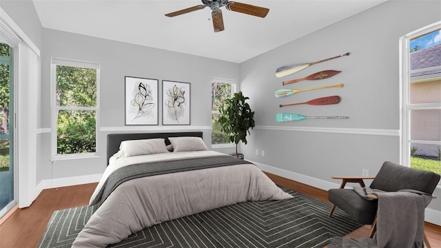 bedroom with multiple windows and hardwood / wood-style floors