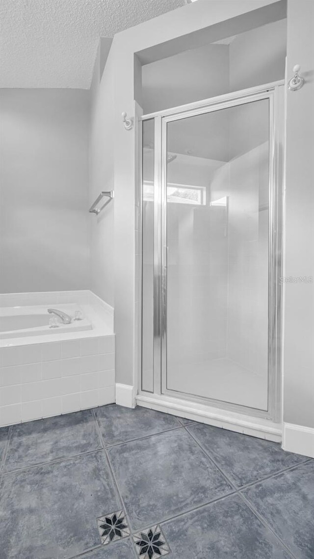 bathroom with a shower with door and a textured ceiling