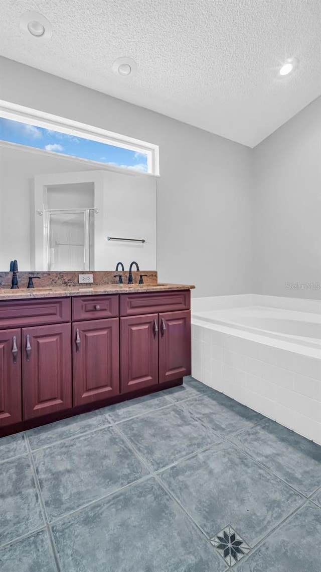 bathroom with vanity, separate shower and tub, and a textured ceiling