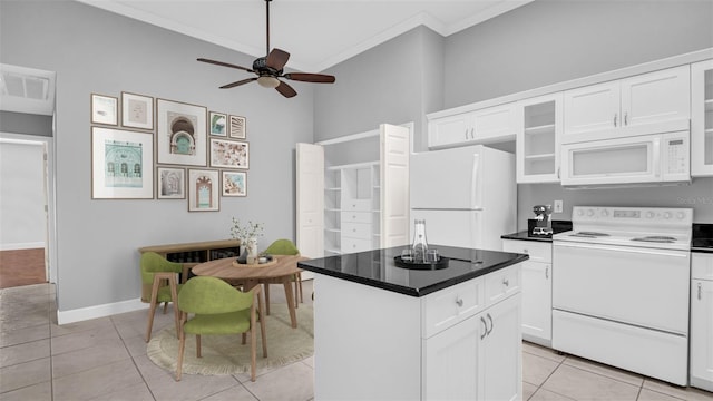 kitchen featuring crown molding, light tile patterned floors, a kitchen island, white appliances, and white cabinets