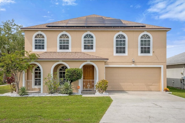 view of front of property with a front lawn, solar panels, and a garage