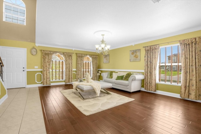 unfurnished living room with ornamental molding, a notable chandelier, and light wood-type flooring