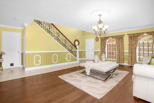 living room featuring hardwood / wood-style flooring, ornamental molding, and a notable chandelier