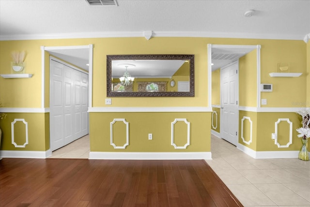 interior space featuring crown molding, an inviting chandelier, and hardwood / wood-style floors