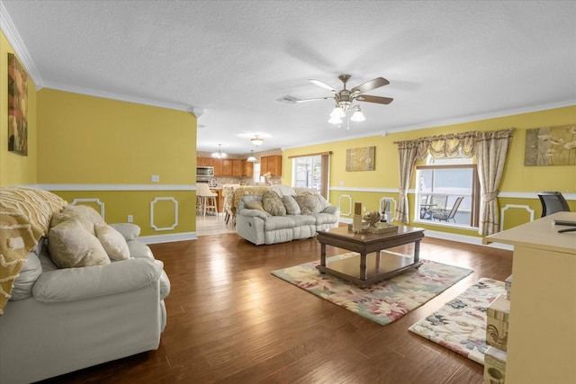 living room with crown molding, plenty of natural light, and dark wood-type flooring