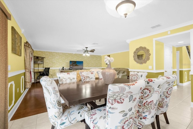 dining space featuring light tile patterned flooring, ceiling fan, and ornamental molding