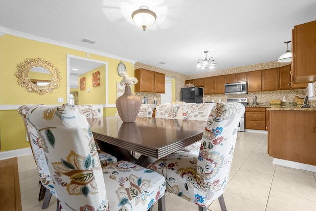 tiled dining area featuring a notable chandelier and crown molding