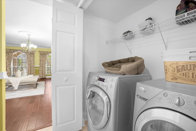 washroom with an inviting chandelier, hardwood / wood-style floors, and independent washer and dryer