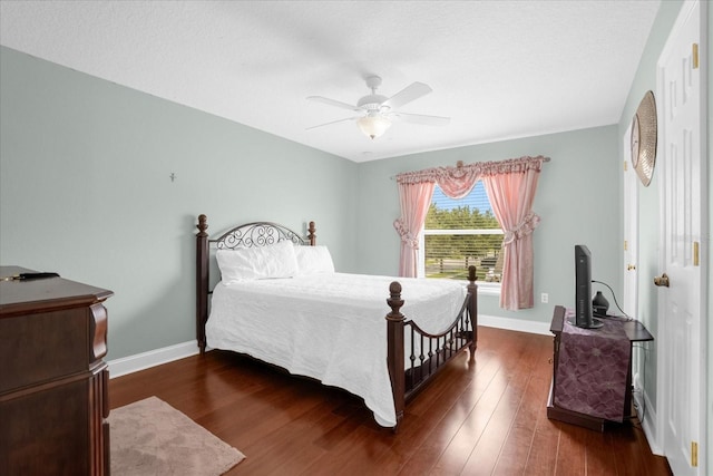 bedroom with dark hardwood / wood-style flooring and ceiling fan