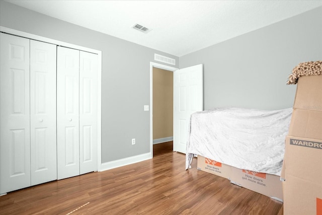 bedroom with hardwood / wood-style flooring and a closet