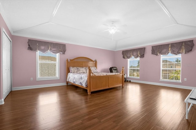 unfurnished bedroom with lofted ceiling, crown molding, and dark wood-type flooring