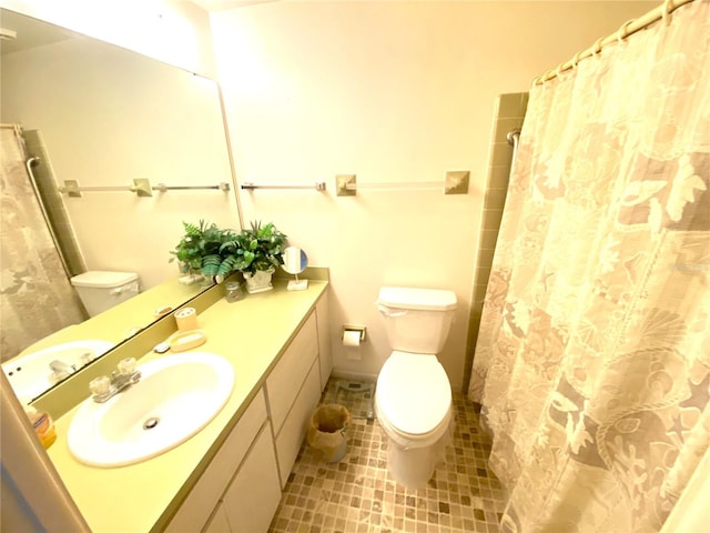 bathroom featuring tile patterned flooring, vanity, walk in shower, and toilet