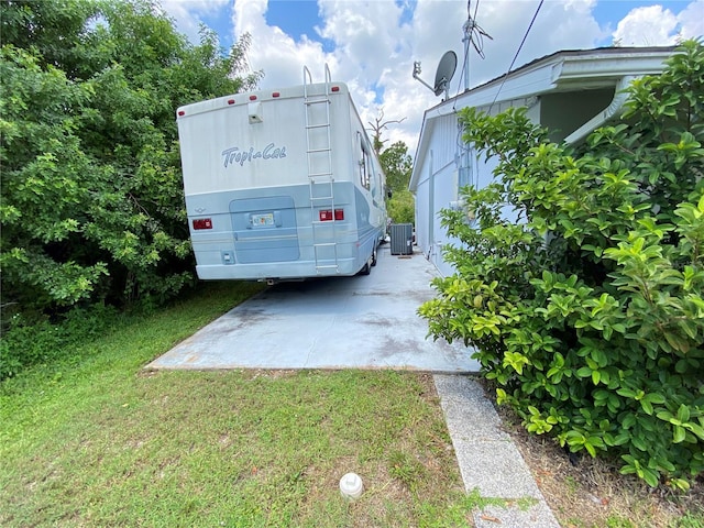 view of vehicle parking with a lawn