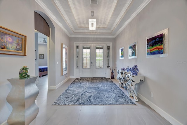 foyer with french doors, a raised ceiling, and light tile patterned floors