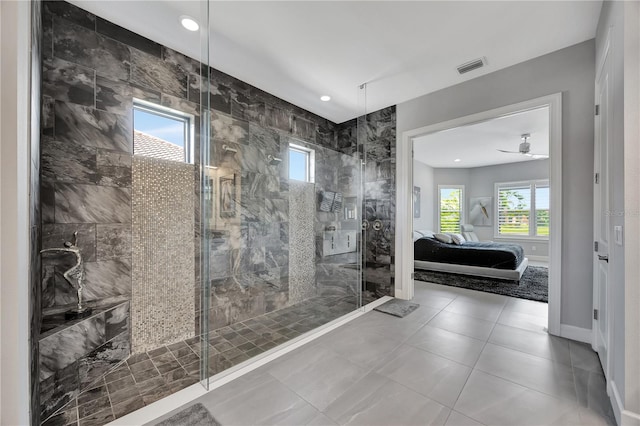 bathroom with a tile shower, ceiling fan, a healthy amount of sunlight, and tile patterned floors