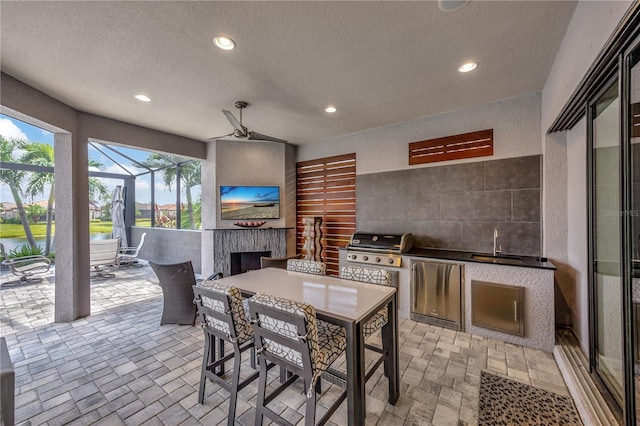 view of patio featuring ceiling fan, grilling area, area for grilling, a lanai, and sink