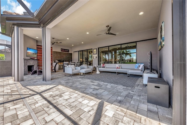 view of patio / terrace with ceiling fan, glass enclosure, and an outdoor hangout area