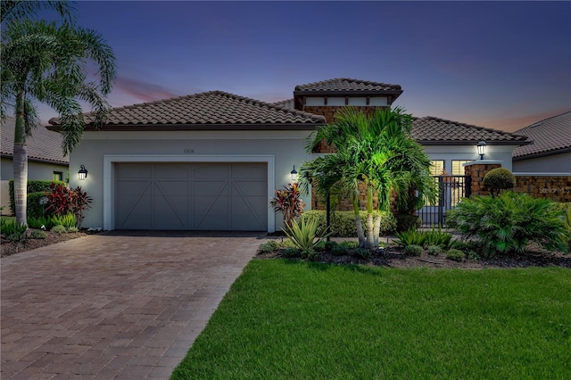 mediterranean / spanish-style home with a yard and a garage