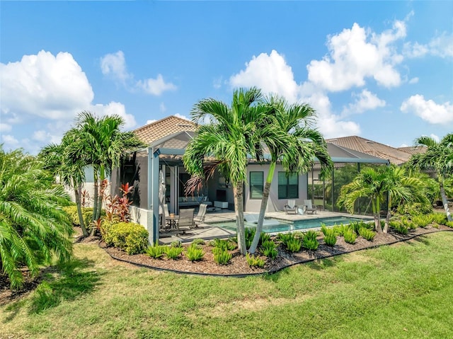 back of property with a patio, a lawn, and glass enclosure