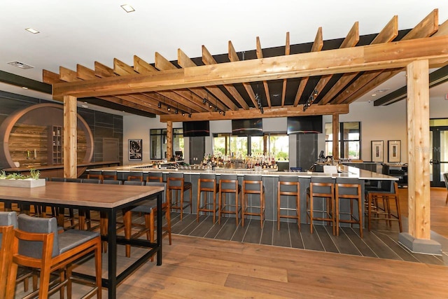 dining room with beam ceiling and wood-type flooring