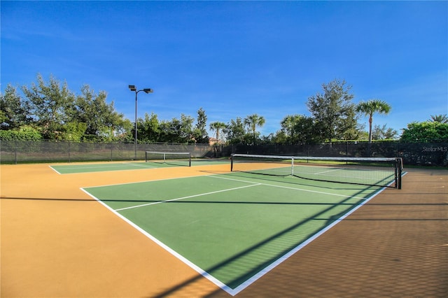 view of tennis court with basketball hoop