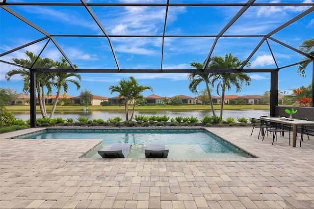 view of pool featuring glass enclosure, a patio area, and a water view