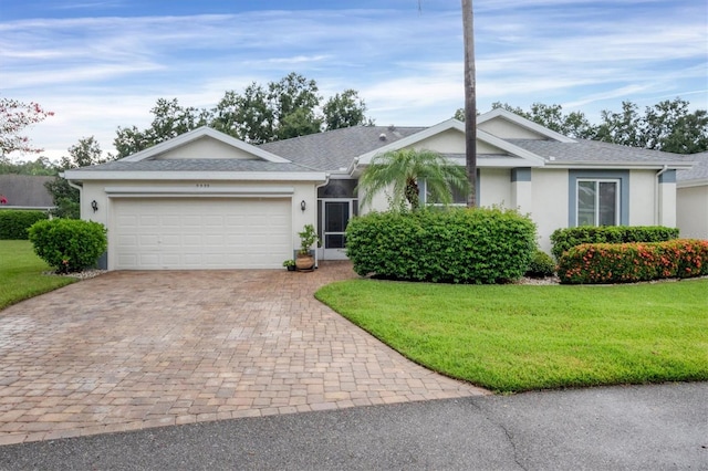 single story home featuring a garage and a front yard