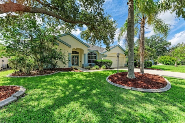 view of front of property with a front yard, a garage, and french doors