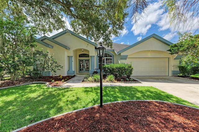 single story home featuring french doors, a front yard, and a garage