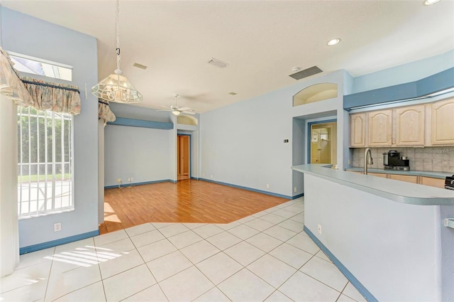 kitchen with pendant lighting, light brown cabinetry, backsplash, and light tile patterned floors