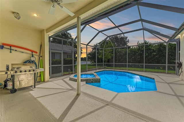 pool at dusk with area for grilling, a patio, glass enclosure, and an in ground hot tub