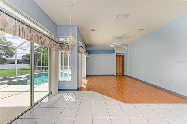 spare room with ceiling fan and light tile patterned floors