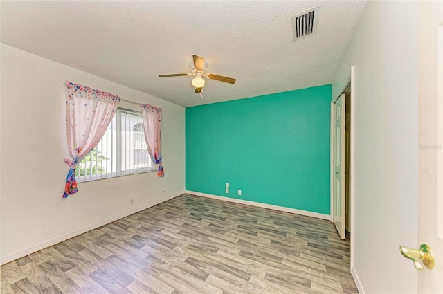 spare room featuring a textured ceiling, ceiling fan, and hardwood / wood-style flooring