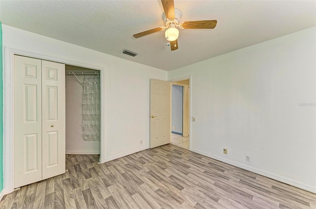 unfurnished bedroom with a textured ceiling, ceiling fan, and light hardwood / wood-style floors