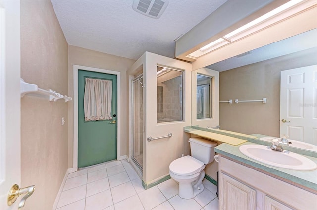 bathroom featuring a textured ceiling, tile patterned flooring, toilet, a shower with door, and vanity