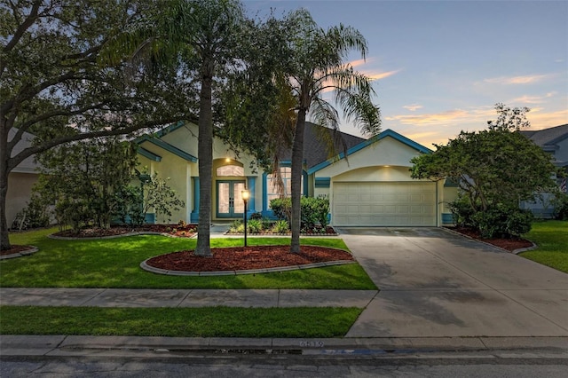 single story home with a yard and a garage