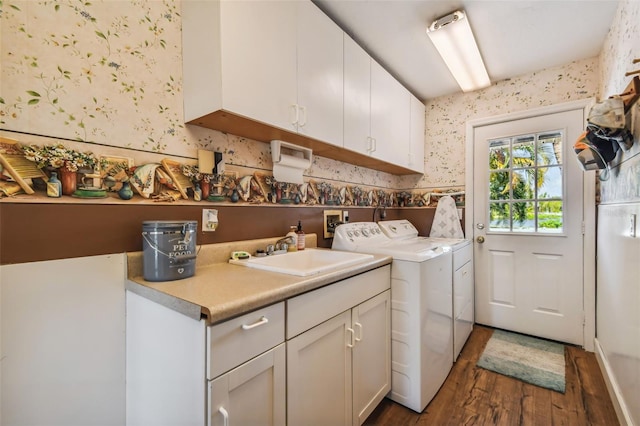 laundry room with sink, washer and clothes dryer, dark hardwood / wood-style floors, and cabinets