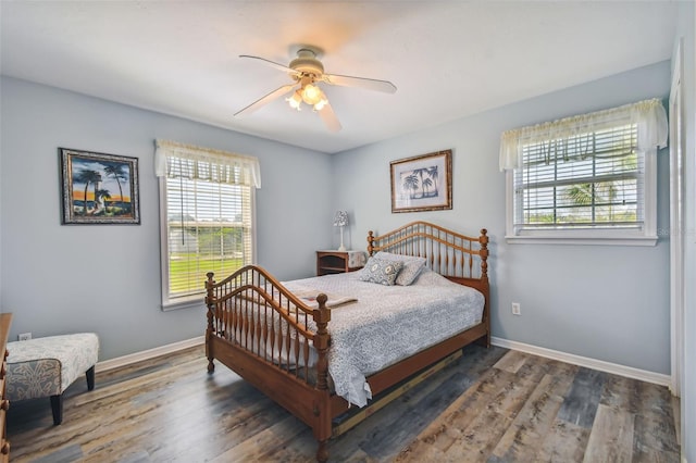 bedroom with ceiling fan, multiple windows, and hardwood / wood-style flooring