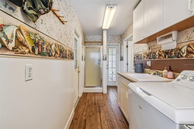 clothes washing area with hardwood / wood-style flooring, sink, cabinets, and separate washer and dryer