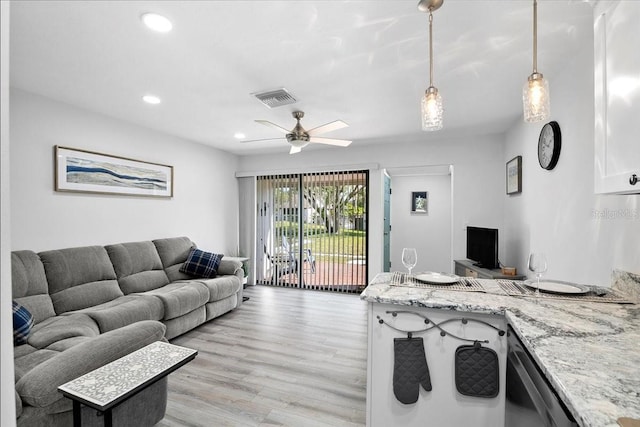 living room with light hardwood / wood-style floors and ceiling fan