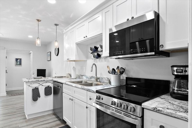 kitchen with white cabinetry, appliances with stainless steel finishes, decorative light fixtures, and sink