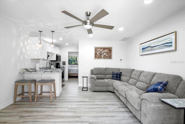 living room with ceiling fan and light hardwood / wood-style floors