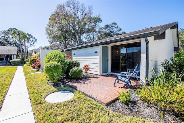 rear view of property with a yard and a patio