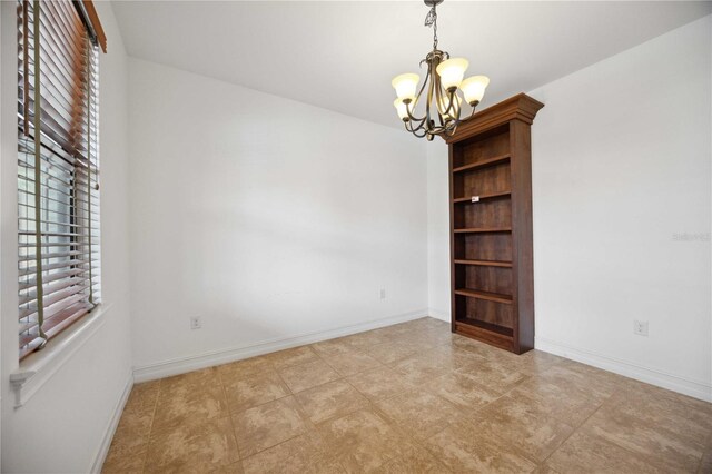 spare room featuring light tile patterned flooring, a chandelier, and a wealth of natural light