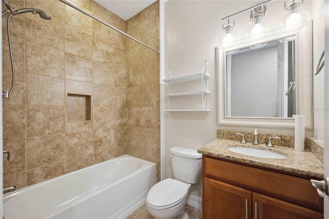 full bathroom with toilet, vanity, and tiled shower / bath