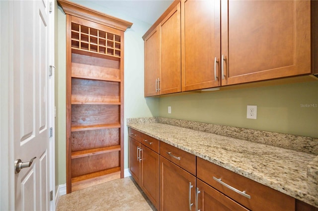 kitchen with light tile patterned flooring and light stone counters